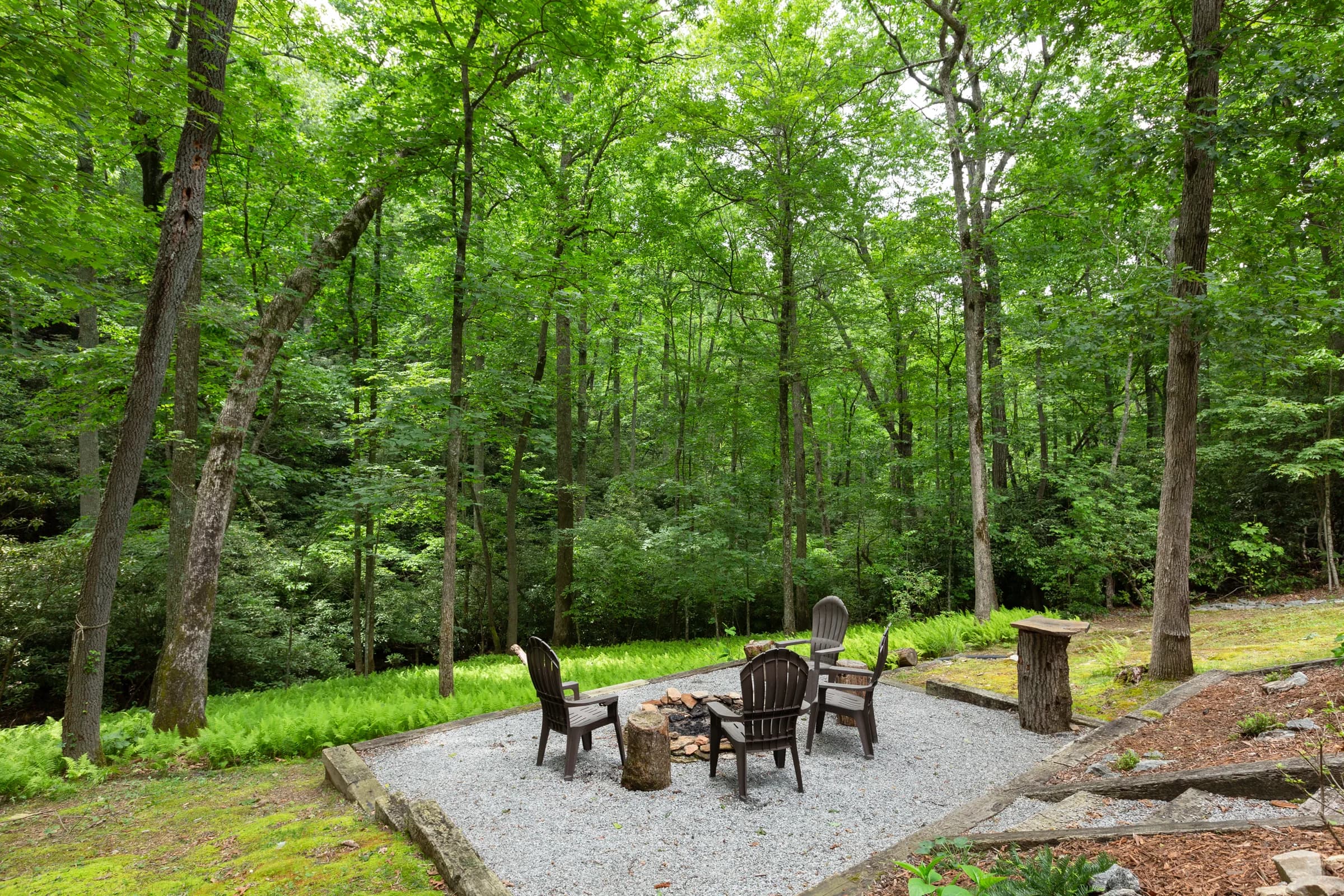 Whispering Trees Cabin fire-pit seating in the woods