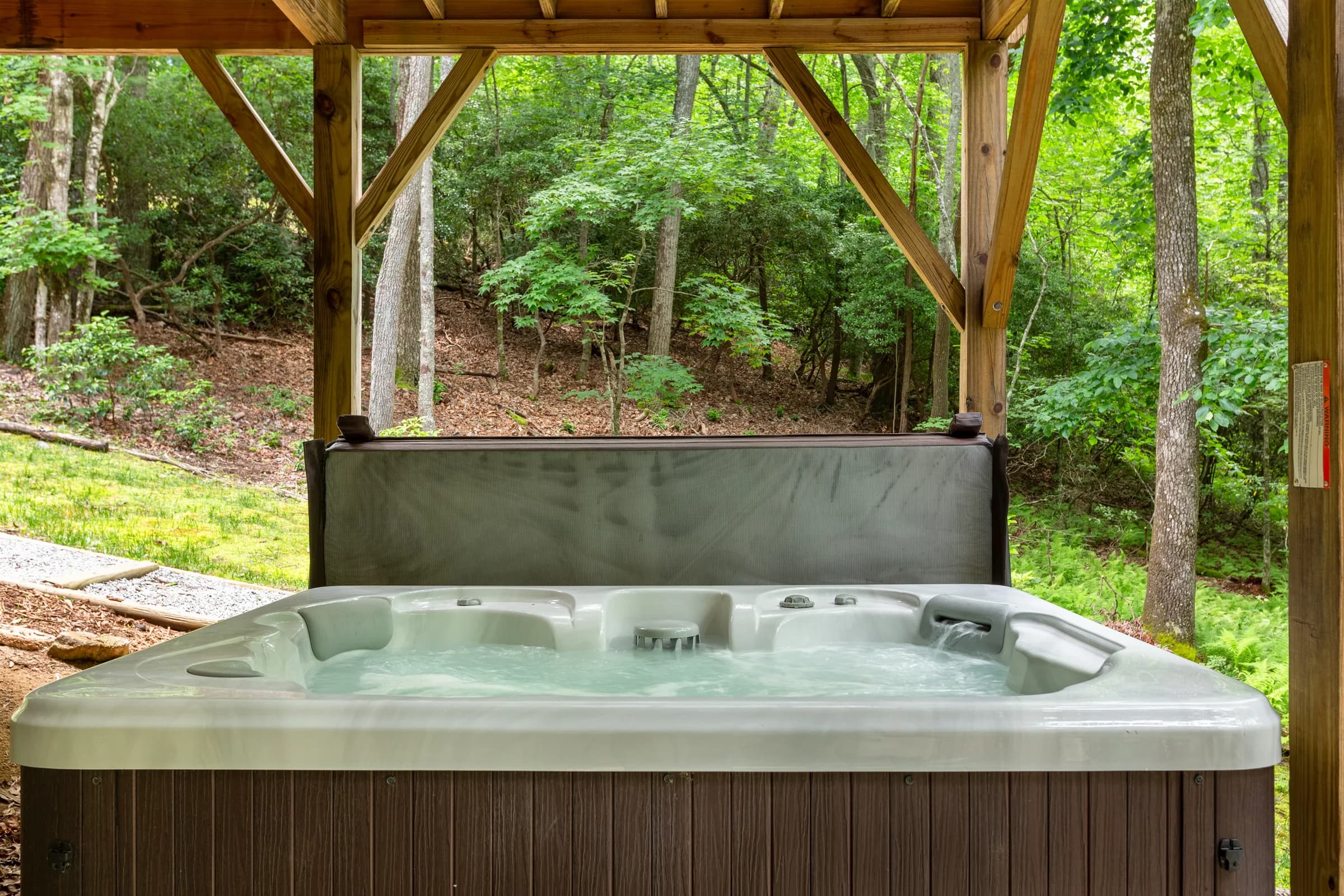 Whispering Trees Cabin hot tub beneath the wooded deck